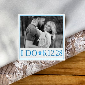 Puede incluir: Una foto en blanco y negro de una pareja abrazándose, con el texto "I DO ♥ 6.12.28" debajo de la foto.