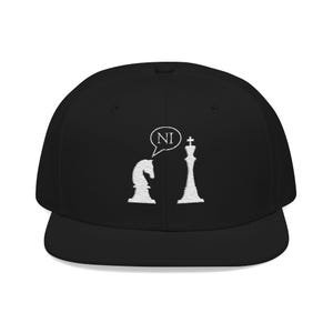 May include: Black baseball cap with a flat brim. The cap features a white embroidered design of a chess knight and king, with a speech bubble containing the letters "NI". A stylish accessory for chess enthusiasts.