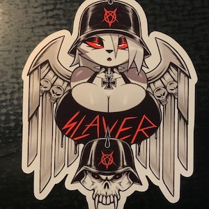 May include: A black and white sticker with a winged, anthropomorphic figure wearing a black helmet with a pentagram. The figure is holding a cross with a swastika. The word "SLAYER" is written in red dripping letters.