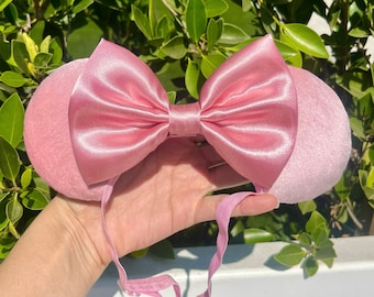 Peut inclure: Un serre-tête avec un nœud en satin rose et des oreilles roses en fourrure. Le serre-tête est fait d'un matériau doux et extensible, parfait pour ajouter une touche de fantaisie à n'importe quelle tenue.