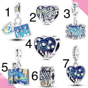 May include: A collection of silver charms featuring the artwork of Vincent van Gogh's "Starry Night." The charms are in various shapes, including hearts, squares, and cylinders, with blue, yellow, and white enamel details.