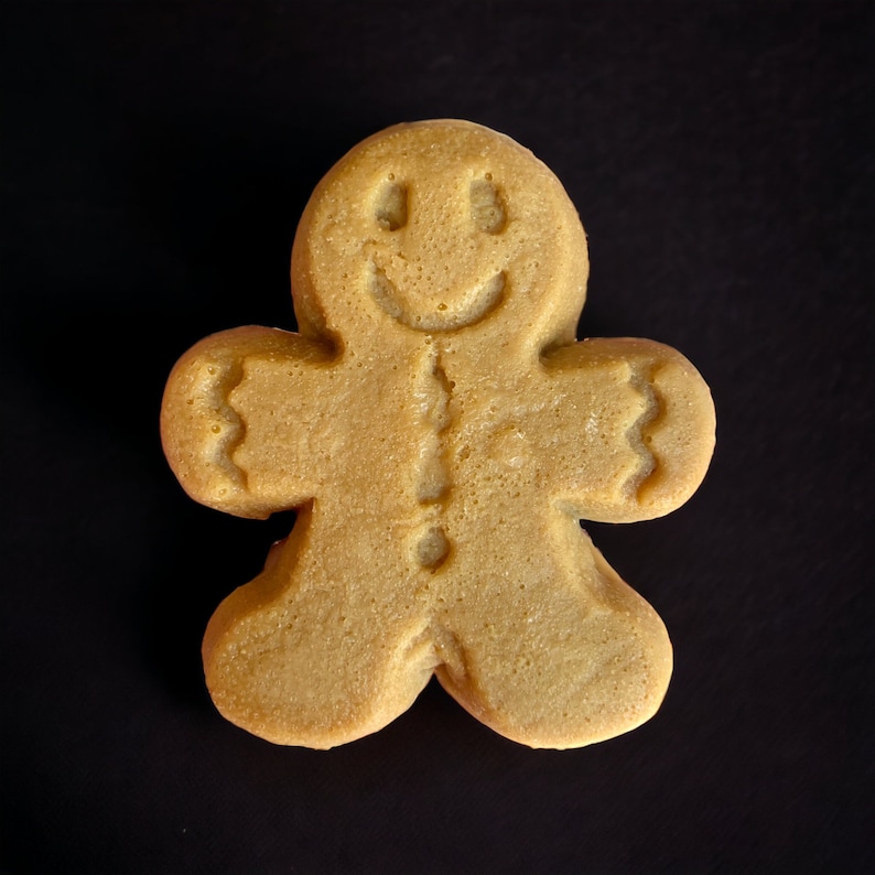 Puede incluir: Una galleta de jengibre con forma de hombre de jengibre con una cara sonriente.