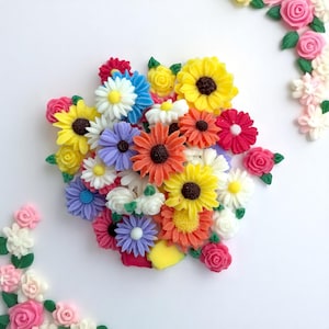 May include: A vibrant assortment of colorful, miniature flowers. The arrangement includes sunflowers, daisies, and roses in shades of yellow, orange, red, blue, and purple. The flowers are arranged on a white background.