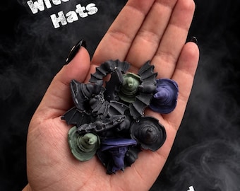 May include: A collection of small, molded wax or resin shapes in the form of witch hats and vampire bats, colored in black, dark green, and purple. The text Witches Hats and Vampire Bats is visible in the image against a dark, smoky background.