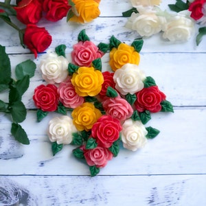 May include: A bouquet of handmade soap flowers in various colours, including red, pink, yellow, and white. The flowers are arranged in a cluster and have a realistic appearance.