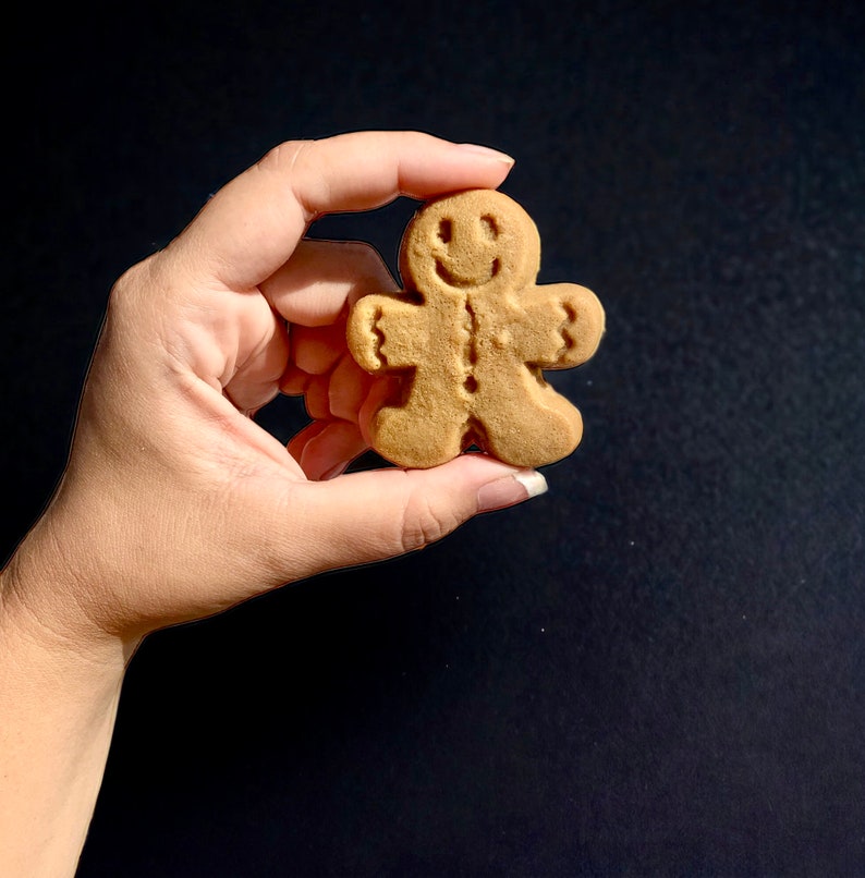 Puede incluir: Una galleta de jengibre con forma de hombre de jengibre sonriente. La galleta es de color marr&oacute;n claro y tiene un dise&ntilde;o sencillo.