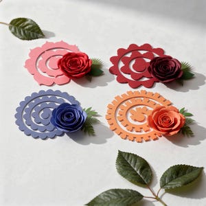 May include: Four paper flower arrangements. Each arrangement features a paper rose in red, burgundy, blue, and orange, with green paper leaves. The roses are attached to decorative paper cutouts in pink, red, blue, and orange.