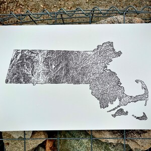 May include: A black and white line drawing of the state of Massachusetts. The drawing is made up of many small lines that create a detailed and intricate design.