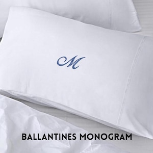 May include: White pillowcase with a blue embroidered letter "M". The pillowcase is part of a bedding set. The text "BALLANTINES MONOGRAM" is printed at the bottom of the image.