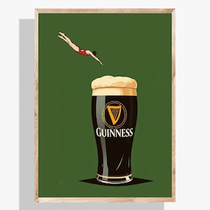 May include: A framed print featuring a pint of Guinness stout with a diver in a red swimsuit. The Guinness glass is black with a white head and the Guinness logo. The background is a solid dark green.