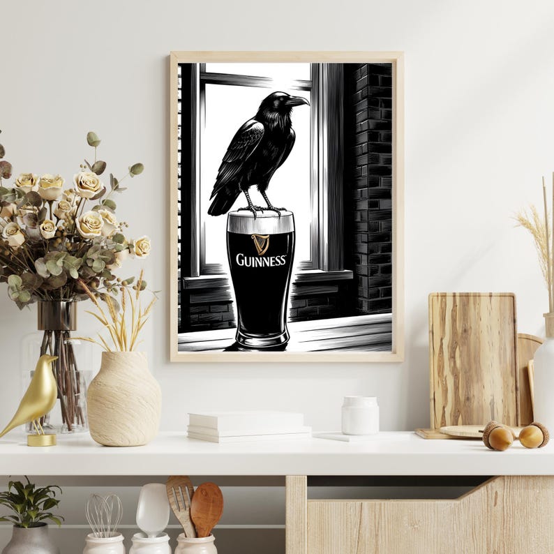 May include: Black and white illustration of a raven perched on top of a glass of Guinness beer. The raven is looking to the right. The glass is on a table in front of a window.