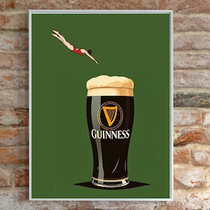 May include: A framed print featuring a pint of Guinness stout with a diver in a red swimsuit above it. The Guinness glass is black with a white head and the Guinness logo. The background is a solid green.