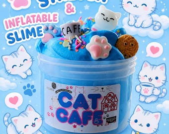 May include: A clear plastic container filled with blue stretch and inflatable slime, decorated with cat-themed embellishments. The container has the words "CAT CAFE" on the front. The image also includes cartoon cats, paw prints, and the words "STRETCH & INFLATABLE SLIME".