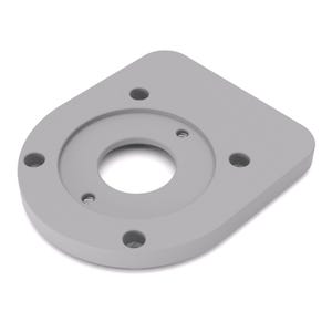 Puede incluir: Un componente rectangular gris claro con esquinas redondeadas y un orificio central circular. El componente tiene cuatro agujeros más pequeños alrededor del centro y tres insertos roscados. El diseño es simétrico y parece estar hecho de un material sólido.