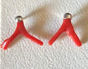 May include: A pair of red coral earrings with silver accents. The coral is shaped like a Y and the earrings are displayed on a white background.
