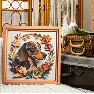 May include: A framed paper art print of a dachshund dog with brown and black fur. The dog is surrounded by paper cutouts of fall leaves in shades of orange, yellow, and green.