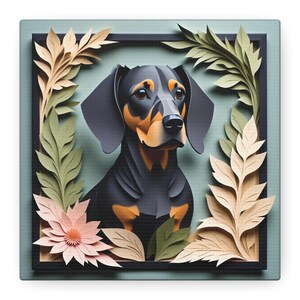 May include: Square canvas art featuring a stylized dachshund dog with black and tan fur, framed by a black border. The dog is surrounded by paper-cut style leaves in shades of green, beige, and a pink flower, set against a muted teal background.
