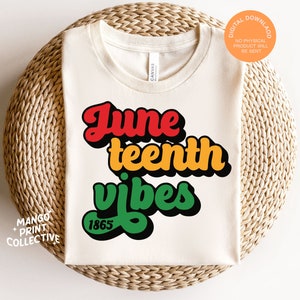 May include: A white t-shirt with the text "Juneteenth vibes" in red, yellow, green, and black lettering. The year "1865" is printed in black below the text.