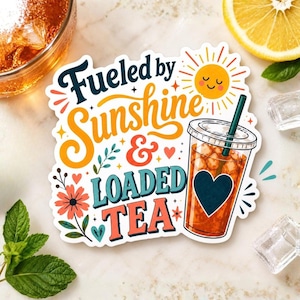 以下が含まれることがあります： Fueled by Sunshine & LOADED TEAという文字が紺色、オレンジ色、赤色で書かれたダイカットステッカー。デザインには、笑顔の黄色い太陽、ピンクの花、そしてアイスティーと黒いハートが入った透明なプラスチックカップが描かれています。
