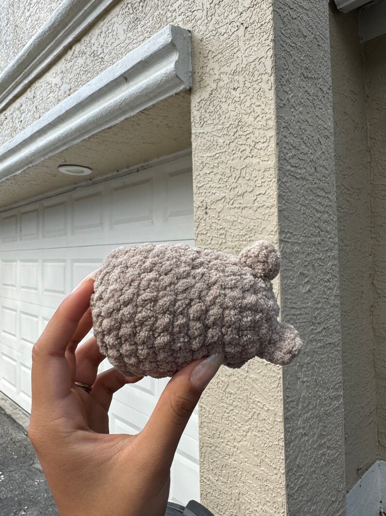 May include: A soft, brown crocheted hat with ear flaps. The hat is made with a fluffy yarn and has a textured, woven design.