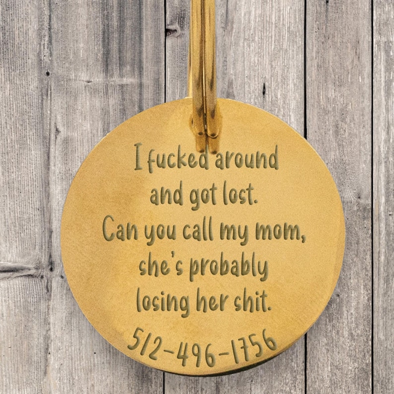 Round gold engraved pet ID tag with funny message that reads “I fcked around and got lost. Can you call my mom, she’s probably losing her sht.” with phone number at bottom. Sturdy metal dog tag with custom etching, durable high-quality plating, and easy-to-attach loop. Perfect for dogs with personality, this humorous pet accessory ensures safety with clear contact info while adding a playful touch.