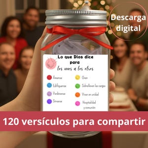 May include: A clear glass jar with a silver lid and a red ribbon tied around it. The jar contains a card with Spanish text and colorful circles. The text includes phrases like "Lo que Dios dice" and "120 versículos para compartir."