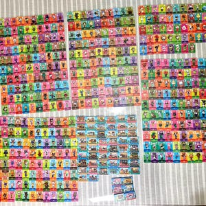 May include: A large collection of rectangular trading cards featuring colourful illustrations of various animal characters and interior scenes. The cards are arranged in multiple grid-like groups, showcasing diverse background colours and character designs.