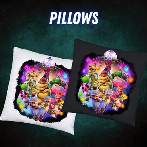 Op de afbeelding: Twee vierkante kussens, &eacute;&eacute;n wit en &eacute;&eacute;n zwart, met een kleurrijk cartoonontwerp. Het ontwerp bevat verschillende personages en het woord "PILLOWS" in witte letters. De kussens lijken van een zacht materiaal te zijn.