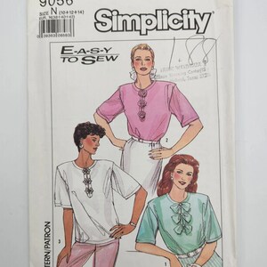 May include: Simplicity sewing pattern number 9056 for sizes 10, 12, and 14. The pattern includes instructions for making three different tops with short sleeves. The tops feature a variety of necklines and embellishments, including a bow, a gathered neckline, and a row of buttons. The pattern is labelled "E-A-S-Y TO SEW".