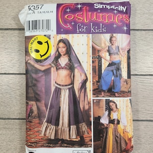 May include: A Simplicity costume pattern for kids, featuring images of children in various costumes. The pattern includes a belly dancer outfit, a cropped top and harem pants, and a medieval-style dress. The package has a Walmart sticker.