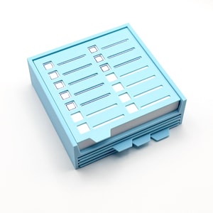 May include: A light blue checklist notepad with a stack of white paper. The notepad has a rectangular shape with a series of horizontal lines and check boxes. The notepad has a light blue frame and tabs.