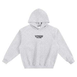 May include: A pale grey hoodie with a drawstring hood. The text "CHRONIC ILLNESS CLUB" is printed in black on the chest. The hoodie is made of a soft, comfortable material.