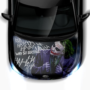 以下が含まれることがあります： ジョーカーをテーマにしたフードラップを施した黒い車。ラップには、緑色の髪と紫色のスーツを着たジョーカーの肖像画と、「WHY SO SERIOUS？」と「HAHAHA」の白い文字が描かれている。