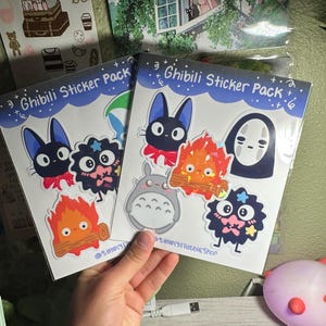 May include: Two sticker packs featuring characters from Studio Ghibli films. The sticker packs are labeled "Ghibili Sticker Pack" and feature characters like Totoro, No Face, and Jiji the cat.