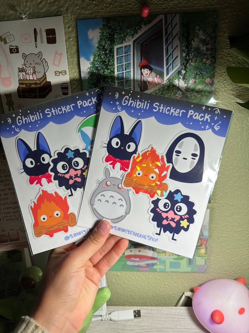 May include: Two sticker packs featuring characters from Studio Ghibli films. The sticker packs are labeled "Ghibli Sticker Pack" and feature characters like Totoro, No Face, and Jiji the cat.