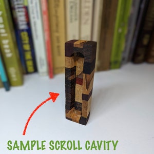 May include: A wooden scroll holder with a rectangular cavity for storing a scroll. The holder is made of various types of wood, including dark brown, light brown, and red wood. The holder is approximately 15 cm tall.