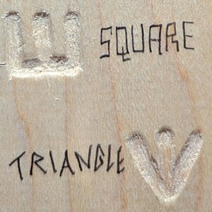 May include: A close-up of a wooden surface with the words "SQUARE" and "TRIANGLE" written in black ink. A square and a triangle are carved into the wood.