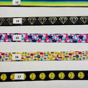 May include: Five different types of elastic hair ties with various patterns. The hair ties are numbered 13 through 17. The patterns include a gradient of blue to green, a black background with gold diamond shapes, a pink and blue geometric pattern, a white background with yellow smiley faces and text, and a black background with yellow softball shapes.