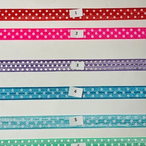 May include: Six different colors of polka dot ribbon with white dots. The ribbon is numbered 1 through 6.