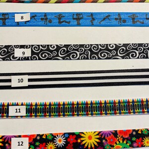 May include: Six different colorful fabric ribbon trims with numbers 7 through 12 printed on white labels. The trims feature various patterns including stripes, swirls, crayons, and flowers.