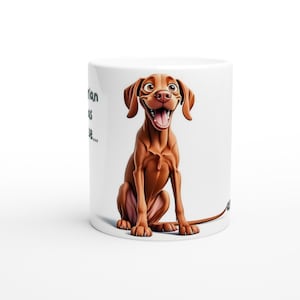 May include: White ceramic mug with a cartoon illustration of a brown and white Vizsla dog with its tongue sticking out. The dog is sitting and looking to the right. The text "A Vizsla is a good idea..." is partially visible on the left side of the mug.