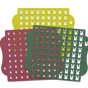 Puede incluir: Tres plantillas superpuestas con un diseño de conejo. La plantilla superior es amarilla, la plantilla del medio es roja y la plantilla inferior es verde.