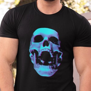 May include: Black t-shirt featuring a vibrant, stylized skull graphic in shades of blue and purple. The skull has an open mouth, creating a striking visual effect. The shirt is a classic crew neck style.