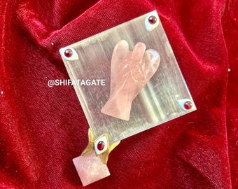 May include: A pink rose quartz angel wing crystal on a clear selenite plate with red and white accents. The plate is on a red velvet surface. @shifatagate