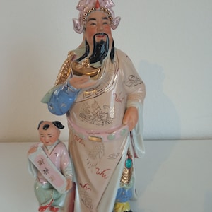 old Chinese porcelain figure of the god of luck with a child