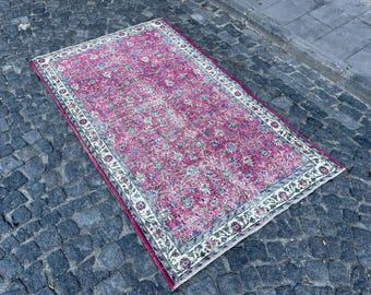 Puede incluir: Una alfombra vintage de color rosa y crema con un patrón floral. La alfombra tiene un aspecto descolorido y está hecha de lana.