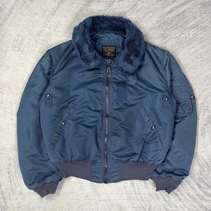 May include: A blue bomber jacket with a faux fur collar. The jacket has a zipper closure, two front pockets, and ribbed cuffs and hem. The jacket is a solid blue color.