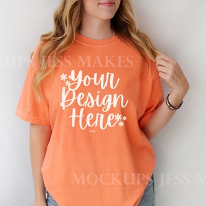 May include: A bright orange t-shirt with a white graphic that says "*your design here*" on the front.