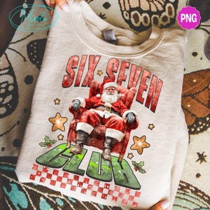 Könnte beinhalten: Beige Sweatshirt mit einem festlichen Design. Es zeigt den Weihnachtsmann in einem roten Sessel, mit dem Text "SIX SEVEN CLUB" in Rot und Grün. Das Design umfasst Sterne und Stechpalmen-Akzente, ideal für Weihnachten.