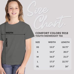 May include: A young person wearing a gray Comfort Colors youth midweight tee. The image includes a size chart with measurements in inches for XS, S, M, L, and XL sizes, detailing width and length.